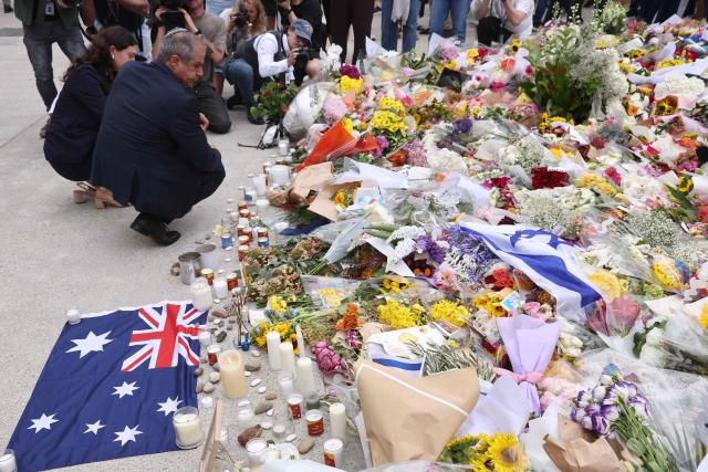 Israeli Ambassador to Australia Amir Maimon (L) pauses at a flower memorial at Bondi Pavilion in Sydney on December 16, 2025, after paying tribute to victims of the Bondi Beach shooting. A father-and-son team toting long-barrelled guns shot and killed 15 people including a 10-year-old girl at Sydney's Bondi Beach on December 14, with authorities labelling it an antisemitic terrorist attack on a Jewish festival. (Photo by DAVID GRAY / AFP)