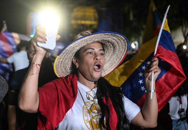 A supporter of Venezuela's President Nicolas Maduro shouts slogans during a rally demanding peace in Caracas on December 15, 2025. The Caribbean nation of Trinidad and Tobago said on December 15, 2025, it had authorized US military aircraft to use its airports, amid growing fears Washington may be preparing an attack on nearby Venezuela. (Photo by Juan BARRETO / AFP)