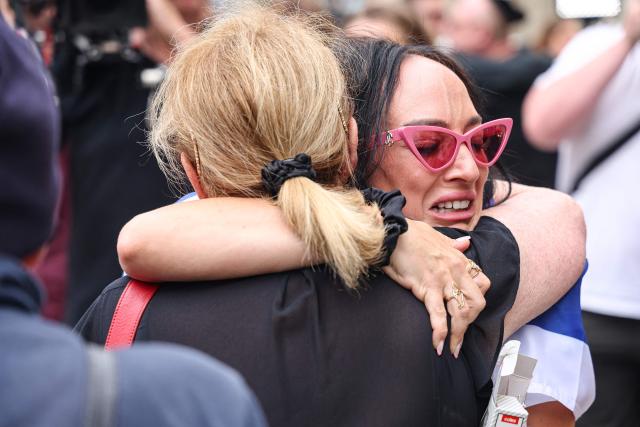 Mourners weep as they gather around floral tributes outside Bondi Pavilion in Sydney on December 16, 2025, to honour victims of the Bondi Beach shooting. Australia's leaders have agreed to toughen gun laws after attackers killed 15 people at a Jewish festival on Bondi Beach, the worst mass shooting in decades decried as antisemitic "terrorism" by authorities. (Photo by DAVID GRAY / AFP)