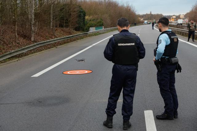 French gendarmes operate a drone for overhead observation of members of Young Farmers of the Yvelines (JA - Jeunes Agriculteurs des Yvelines) partially blocading of the N12 road in Mere in the Yvelines outside Paris on December 16, 2025, as part of nationwide action by farmers to protest against the government's mandatory culling protocol for cattle herds affected by lumpy skin disease (dermatose nodulaire contagieuse), a viral disease first detected in France in June 2025 that has led to the slaughter of over 3,000 cattle across more than 110 outbreaks nationwide, and against an EU trade deal with Mercosur countries. (Photo by GEOFFROY VAN DER HASSELT / AFP)
