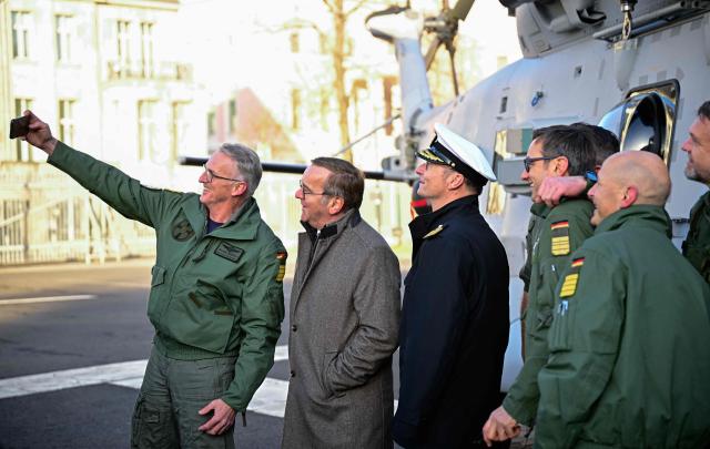 German Defence Minister Boris Pistorius (2ndL) poses for a selfier with  Captain Broder Nielsen (L) and Vice Admiral Axel Deertz (3rdL), Commander of the German Fleet and Supporting Forces of the German Naval Air Command, and crew members in front of a Sea Tiger Sea Tiger shipboard helicopter NH-90 MRFH after it landed in the courtyard of the Defence ministry prior to a handing over ceremony of the first of these helicopters to the German Navy, on December 16, 2025 in Berlin. The Sea Tiger is a high-performance and versatile shipborne helicopter, developed for national and alliance defense. A total of 30 NH-90 MRFH Sea Tiger helicopters will be stationed with Naval Air Wing 5 in Nordholz, Lower Saxony. (Photo by Tobias SCHWARZ / AFP)