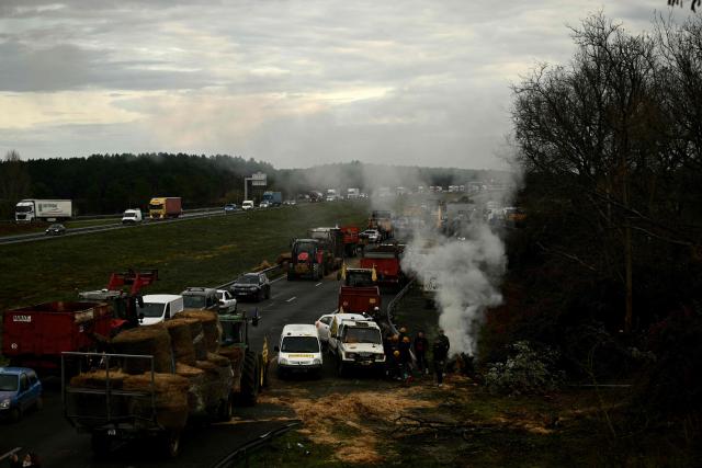 French farmers block the A63 motorway at the Cestas interchange in Gironde, south-western France on December 16, 2025. French farmers have been protesting against the government's mandatory culling protocol for cattle herds affected by lumpy skin disease (dermatose nodulaire contagieuse), a viral disease first detected in France in June 2025 that has led to the slaughter of over 3,000 cattle across more than 110 outbreaks nationwide. (Photo by Philippe LOPEZ / AFP)