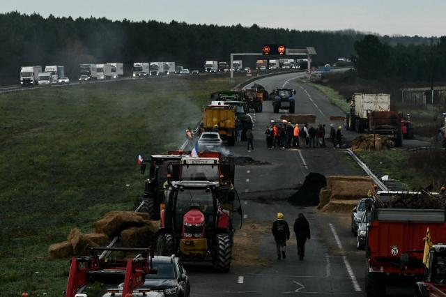 French farmers block the A63 motorway at the Cestas interchange in Gironde, south-western France on December 16, 2025. French farmers have been protesting against the government's mandatory culling protocol for cattle herds affected by lumpy skin disease (dermatose nodulaire contagieuse), a viral disease first detected in France in June 2025 that has led to the slaughter of over 3,000 cattle across more than 110 outbreaks nationwide. (Photo by Philippe LOPEZ / AFP)
