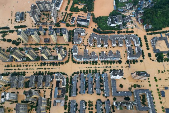 (FILES) An aerial photo shows flooded buildings in Rongjiang, in Chinas southwest Guizhou province on June 24, 2025. Global economic losses from natural disasters are projected to have dropped by 33 percent to $220 billion in 2025, despite the damage wrought by the Los Angeles wildfires, reinsurer Swiss Re said on December 16, 2025. The total cost of insured losses from natural catastrophes is estimated at $107 billion, down 24 percent from the previous year, the Zurich-based reinsurance giant said in its preliminary estimates for 2025. (Photo by AFP) / China OUT