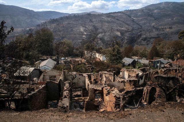 (FILES) A general view of San Vicente de Leira, in the Spanish northwestern province of Ourense is seen after a wildfire on August 19, 2025. Global economic losses from natural disasters are projected to have dropped by 33 percent to $220 billion in 2025, despite the damage wrought by the Los Angeles wildfires, reinsurer Swiss Re said on December 16, 2025. The total cost of insured losses from natural catastrophes is estimated at $107 billion, down 24 percent from the previous year, the Zurich-based reinsurance giant said in its preliminary estimates for 2025. (Photo by MIGUEL RIOPA / AFP)