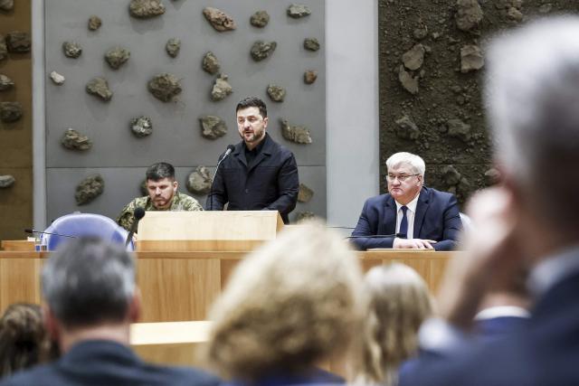 Ukrainian President Volodymyr Zelensky (C) delivers a speech The Netherlands' House of Representatives in The Hague, on December 16, 2025. Zelensky is in The Hague for a conference discussing compensations for Ukraine for the consequences of Russian aggression. (Photo by Robin VAN LONKHUIJSEN / ANP / AFP) / Netherlands OUT