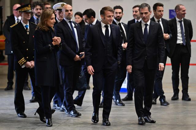 France's President Emmanuel Macron arrives to address the audience during a meeting with some readers of the daily newspaper "La Provence" as part of his visit to Marseille, southern France, on December 16, 2025. (Photo by Miguel MEDINA / POOL / AFP)