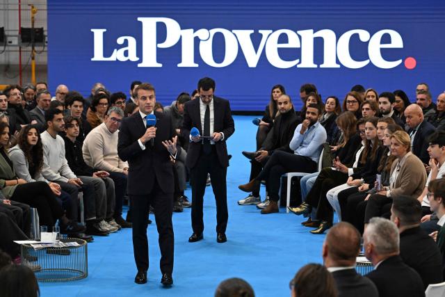 France's President Emmanuel Macron addresses the audience during a meeting with some readers of the daily newspaper "La Provence" as part of his visit to Marseille, southern France, on December 16, 2025. (Photo by Miguel MEDINA / POOL / AFP)