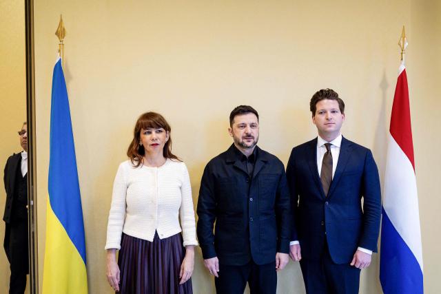 Ukrainian President Volodymyr Zelensky (C) poses with Senate Speaker Mei Li Vos (L) and House Speaker Thom van Campen (R) at the Dutch House of Representatives in The Hague, on December 16, 2025. (Photo by Robin van Lonkhuijsen / ANP / AFP) / Netherlands OUT