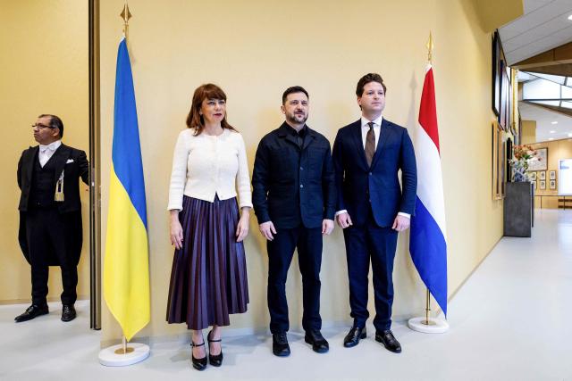 Ukrainian President Volodymyr Zelensky (C) poses with Senate Speaker Mei Li Vos (L) and House Speaker Thom van Campen (R) at the Dutch House of Representatives in The Hague, on December 16, 2025. (Photo by Robin van Lonkhuijsen / ANP / AFP) / Netherlands OUT