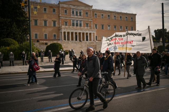 Greek public sector workers take part in a demonstration during a 24-hour strike against the 2026 budget undergoing government review, in Athens on December 16, 2025. (Photo by Aris MESSINIS / AFP)
