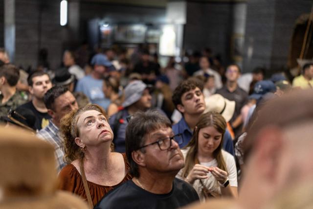 An attendee looks up at the light beam that shines through the roof that will later shine on the cenotaph as Afrikaners gather to celebrate the Day of the Vow (Geloftedag) at the Voortrekker Monument in Pretoria on December 16, 2025. The Day of the Vow (Geloftedag), which has since been renamed Reconciliation Day, is celebrated by traditional Afrikaners as the day they defeated the Zulu's at the Battle of Blood River, in KwaZulu Natal, on December 16, 1838. (Photo by Wikus de Wet / AFP)