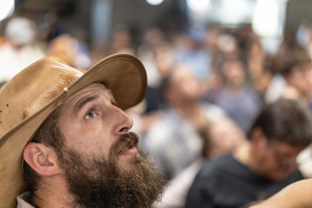 An attendee looks up at the light beam that shines through the roof that will later shine on the cenotaph as Afrikaners gather to celebrate the Day of the Vow (Geloftedag) at the Voortrekker Monument in Pretoria on December 16, 2025. The Day of the Vow (Geloftedag), which has since been renamed Reconciliation Day, is celebrated by traditional Afrikaners as the day they defeated the Zulu's at the Battle of Blood River, in KwaZulu Natal, on December 16, 1838. (Photo by Wikus de Wet / AFP)