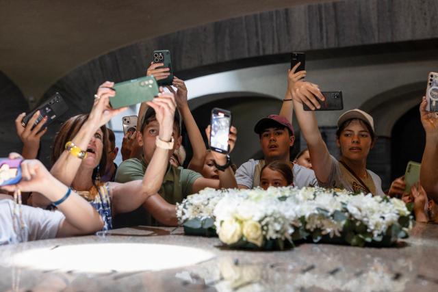 Attendees react as a light shines on the cenotaph as Afrikaners gather to celebrate the Day of the Vow (Geloftedag) at the Voortrekker Monument in Pretoria on December 16, 2025. The Day of the Vow (Geloftedag), which has since been renamed Reconciliation Day, is celebrated by traditional Afrikaners as the day they defeated the Zulu's at the Battle of Blood River, in KwaZulu Natal, on December 16, 1838. (Photo by Wikus de Wet / AFP)