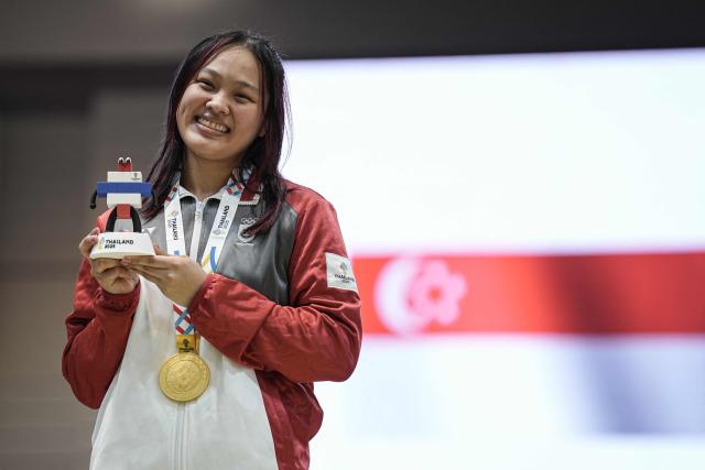 Singapore's Elle Koh Meihui poses with her gold medal after her victory in the women's individual epee final during the 33rd Southeast Asian Games (SEA Games) at Fashion Island mall in Bangkok on December 16, 2025. (Photo by Chanakarn Laosarakham / AFP)