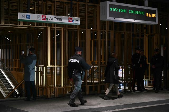 An Italian police officer patrols in the 'Colosseo' new Metro station, designed as a museum to showcase the archaeological findings uncovered during its construction, as it opens to the public, in Rome on December 16, 2025. (Photo by Filippo MONTEFORTE / AFP)