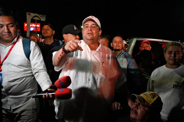 Tegucigalpa's Mayor Jorge Aldana speaks after some of his supporters were injured during an eviction by the National Civil Police and the Military Police of Public Order (PMOP) in the surroundings of the National Institute of Professional Training (INFOP), where the National Electoral Council (CNE) will carry out the scrutiny, after the vote count was interrupted several times due to computer failures, in Tegucigalpa on December 16, 2025. At least eight people were injured on Monday night during an operation to remove left-wing militants who were pressing for the final results of the general elections in Honduras, authorities reported on Tuesday. More than two weeks after the elections, Hondurans still do not know the winner of the presidential race or other elected officials in positions such as mayor of the capital, Tegucigalpa. (Photo by Orlando SIERRA / AFP)