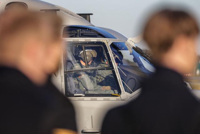An armored honor guard stands as a NH-90 MRFH Sea Tiger shipboard helicopter lands at the naval airbase of Nordholz, northern Germany, on December 16, 2025, as the German Navy is taking delivery of the first of approximately 30 new shipborne helicopters of this type. The Sea Tiger is a high-performance and versatile shipborne helicopter, developed for national and alliance defense. A total of 30 NH-90 MRFH Sea Tiger helicopters will be stationed with Naval Air Wing 5 in Nordholz, Lower Saxony. (Photo by FOCKE STRANGMANN / AFP)