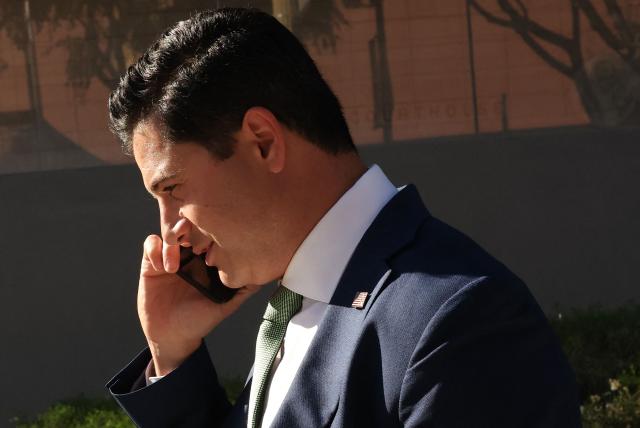 Bill Essayli, First Assistant United States Attorney for the Central District of California, speaks on the phone outside the United States District Court ahead of the sentencing hearing of former medical doctor Mark Chavez on charges of conspiracy to distribute ketamine connected to the overdose death of actor Matthew Perry in Los Angeles, California, on December 16, 2025. (Photo by Patrick T. Fallon / AFP)