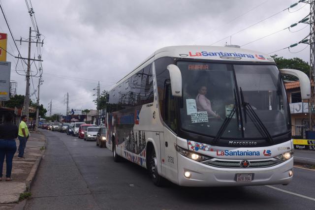 A contingency bus provided by the government rides along a street during a two-day strike of drivers of public transportation in Asuncion, on December 16, 2025. Drivers are protesting against a transport reform law and the measure affects 80% of the service of the Paraguayan capital and surroundings. (Photo by DANIEL DUARTE / AFP)