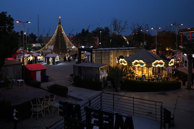 A photograph shows a Christmas market at an amusement park in Basra on December 16, 2025. (Photo by Hussein FALEH / AFP)