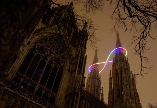 The new light installation "Infinity of Light" by Austrian artist Billi Thanner illuminiates around the steeples of the Votive church in Vienna on December 16, 2026 (Photo by Joe Klamar / AFP)