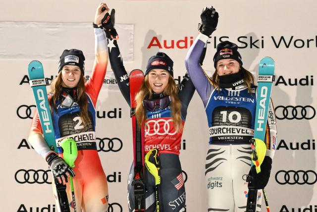 (from L) Second placed Switzerland's Camille Rast, winner US' Mikaela Shiffrin and third placed Germany's Emma Aicher celebrate on the podium after the FIS Alpine Skiing women's World Cup 2025-2026 slalom in Courchevel, French Alps, on December 16, 2025. (Photo by Jeff PACHOUD / AFP)