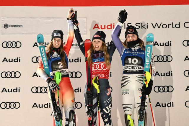 (from L) Second placed Switzerland's Camille Rast, winner US' Mikaela Shiffrin and third placed Germany's Emma Aicher celebrate on the podium after the FIS Alpine Skiing women's World Cup 2025-2026 slalom in Courchevel, French Alps, on December 16, 2025. (Photo by Jeff PACHOUD / AFP)