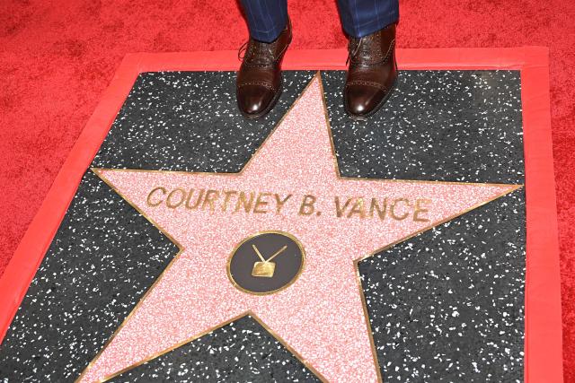 US actor Courtney B. Vance (detail shoes) poses on his star during his Hollywood Walk of Fame unveiling ceremony in Hollywood, California, on December 16, 2025. (Photo by Robyn Beck / AFP)