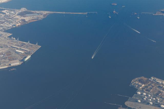 Boats pass along the Patapsco River near the site of the fallen Francis Scott Key Bridge, on December 16, 2025. On March 26, 2024, the Dali, a 984-foot Singapore-flagged container ship, suffered a series of electrical problems and crashed into the Francis Scott Key Bridge over the Patapsco River in Maryland, which collapsed like a house of cards. (Photo by Tom BRENNER / POOL / AFP)