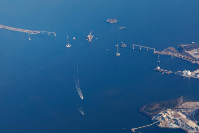 Boats pass along the Patapsco River near the site of the fallen Francis Scott Key Bridge, on December 16, 2025. On March 26, 2024, the Dali, a 984-foot Singapore-flagged container ship, suffered a series of electrical problems and crashed into the Francis Scott Key Bridge over the Patapsco River in Maryland, which collapsed like a house of cards. (Photo by Tom BRENNER / POOL / AFP)