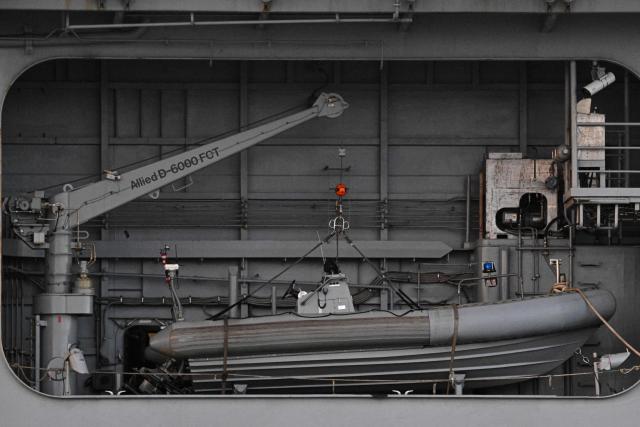 The Wasp-class amphibious assault ship USS Iwo Jima (LHD7) is docked at Rafael Cordero Santiago Port of the America on December 16, 2025 in Ponce, Puerto Rico. President Donald Trump administration is conducting a military campaign in the Caribbean and eastern Pacific, deploying naval and air forces for what it calls an anti-drugs offensive. (Photo by Miguel J. Rodriguez Carrillo / AFP)