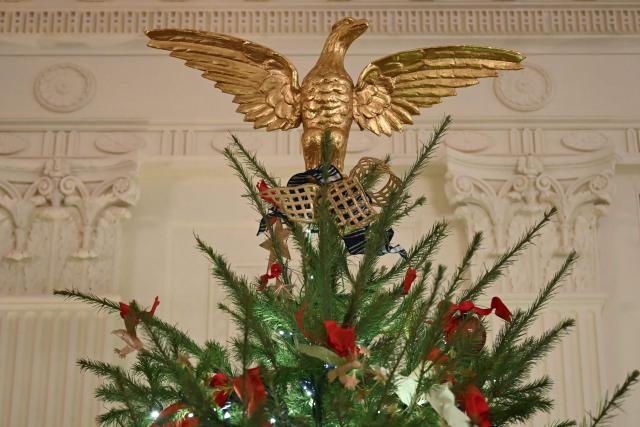A golden eagle is seen at the top of a Christmas tree in the East Room of the White House in Washington, DC on December 16, 2025. (Photo by ANDREW CABALLERO-REYNOLDS / AFP)