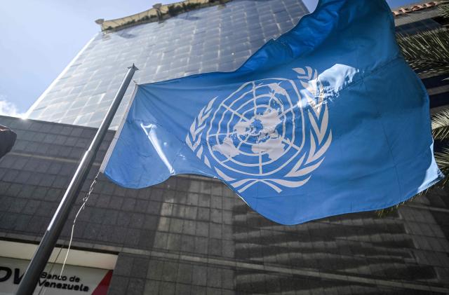 The United Nations flag waves in front of its office building in Caracas on December 16, 2025. (Photo by Juan BARRETO / AFP)