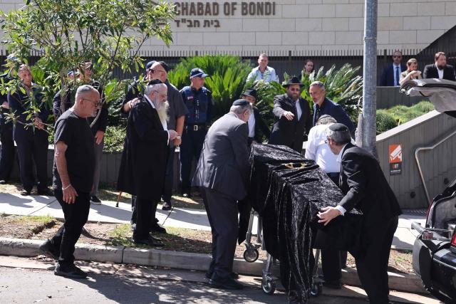 The coffin of rabbi Eli Schlanger, who was killed in the December 14 Bondi beach shooting attack, arrives for his funeral service at the Chabad of Bondi Synagogue in Sydney on December 17, 2025. Mourners cried on December 17 as they wheeled the coffin into the first funeral service for victims of the Bondi Beach mass shooting, an AFP journalist saw. Huge crowds are expected to cram the Chabad of Bondi Synagogue in Sydney to pay their respects to slain rabbi Eli Schlanger, the first of 15 victims to be laid to rest. (Photo by DAVID GRAY / AFP)