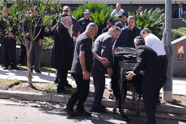 The coffin of rabbi Eli Schlanger, who was killed in the December 14 Bondi beach shooting attack, arrives at the Chabad of Bondi Synagogue in Sydney on December 17, 2025. Mourners cried on December 17 as they wheeled the coffin into the first funeral service for victims of the Bondi Beach mass shooting, an AFP journalist saw. Huge crowds are expected to cram the Chabad of Bondi Synagogue in Sydney to pay their respects to slain rabbi Eli Schlanger, the first of 15 victims to be laid to rest. (Photo by DAVID GRAY / AFP)