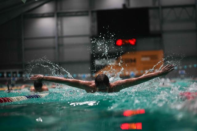 Local residents and children swim in Kharkiv’s largest swimming pool, which has been damaged multiple times by shelling, on October 17, 2025. "Water and swimming cure everything," educator Ayuna Morozova firmly believes. "First two years of Covid, then four years of war -- children are going mad," she said. The complex is now also home to a water therapy space for amputee soldiers. (Photo by OLEKSII FILIPPOV / AFP)