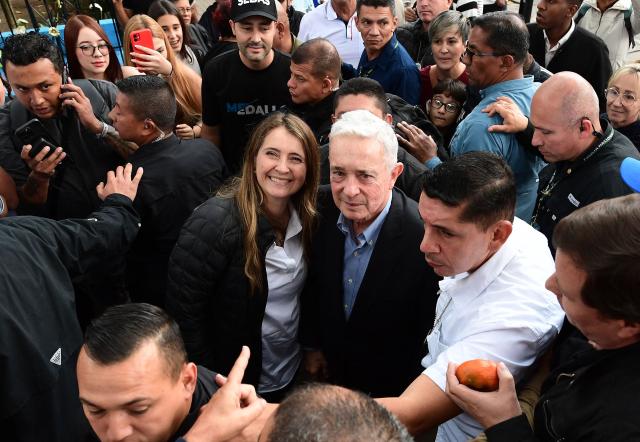 Colombian senator Paloma Valencia (C, left), presidential candidate for the Democratic Center party, and former president Alvaro Uribe (C, right) attend a community dialogue at the central park in La Estrella, Antioquia department, Colombia, on December 16, 2025. Colombia's main opposition party on December 15 chose as its candidate to succeed leftist Gustavo Petro in 2026 a senator aligned with Donald Trump who backs his pressure on Venezuelan President Nicolas Maduro. (Photo by JAIME SALDARRIAGA / AFP)