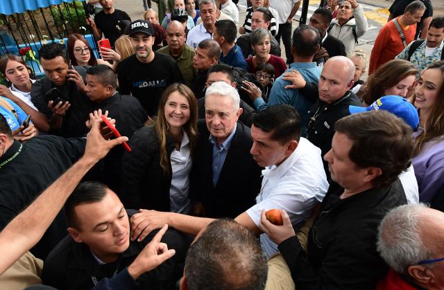 Colombian senator Paloma Valencia (C, left), presidential candidate for the Democratic Center party, and former president Alvaro Uribe (C) attend a community dialogue at the central park in La Estrella, Antioquia department, Colombia, on December 16, 2025. Colombia's main opposition party on December 15 chose as its candidate to succeed leftist Gustavo Petro in 2026 a senator aligned with Donald Trump who backs his pressure on Venezuelan President Nicolas Maduro. (Photo by JAIME SALDARRIAGA / AFP)