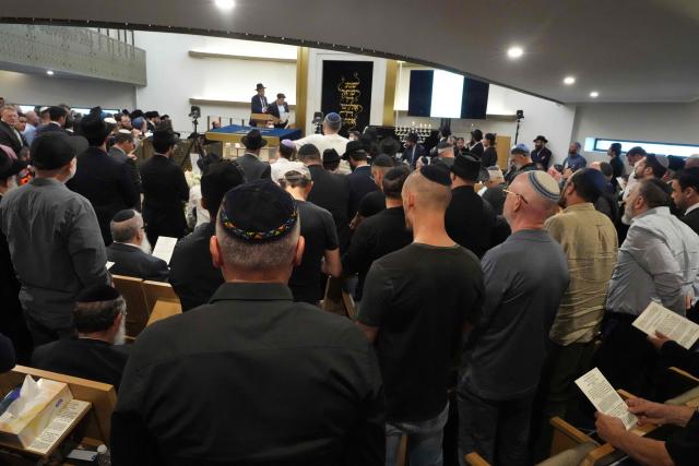 Mourners gather at a synagogue for the funeral of Rabbi Eli Schlanger, a victim in the Bondi Beach mass shooting, in Bondi, Sydney, Australia on December 17, 2025. (Photo by Mark Baker / POOL / AFP)