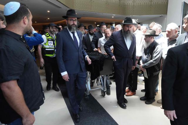 The coffin of rabbi Eli Schlanger, who was killed in the December 14 Bondi beach shooting attack, is escorted out of a synagogue after his funeral at the Chabad of Bondi Synagogue in Sydney on December 17, 2025. Australia held the first funeral on December 17 for victims of the Bondi Beach mass shooting, as large crowds gathered to grieve a rabbi slain in the attack. Sajid Akram and his son Naveed opened fire on a Jewish festival at the famed surf beach on December 14 evening, killing 15 people and wounding dozens more. (Photo by Mark Baker / POOL / AFP)