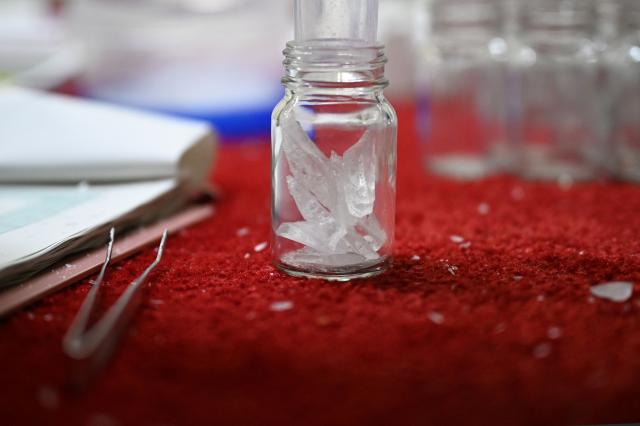 Slices of ice from an ice core sample taken from a glacier in the Pamir mountain range in Tajikistan are seen in a bottle at the Hokkaido University Institute of Low Temperature Science, in Sapporo, in northern Japan’s Hokkaido prefecture on December 9, 2025. Dressed in an orange puffer jacket, Japanese glacier scientist Yoshinori Iizuka stepped into a storage freezer chilled to minus 50 Celcius to retrieve an ice core. (Photo by GREG BAKER / AFP) / TO GO WITH: Japan-Tajikistan-climate-science-environment-research, FOCUS by Hiroshi HIYAMA