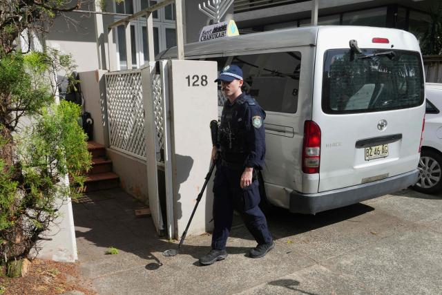 Police perform a sweep outside the Chabad of Bondi Synagogue in Sydney on December 17, 2025, during the funeral of rabbi Eli Schlanger, who was killed in the December 14 Bondi Beach mass shooting. Australia held the first funeral on December 17 for victims of the Bondi Beach mass shooting, as large crowds gathered to grieve a rabbi slain in the attack. Sajid Akram and his son Naveed opened fire on a Jewish festival at the famed surf beach on December 14 evening, killing 15 people and wounding dozens more. (Photo by Mark Baker / POOL / AFP)