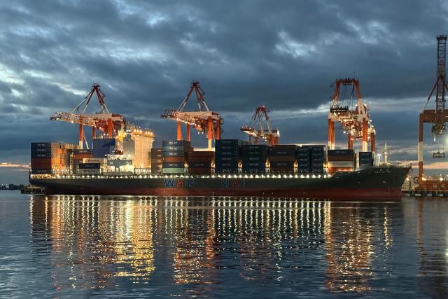 A cargo ship unloads containers at the Manila international port in Manila on December 16, 2025. (Photo by Ted ALJIBE / AFP)