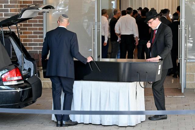 The coffin of Yaakov Levitan, who was killed in the December 14 Bondi beach shooting attack, arrives at the Macquarie Park Cemetery in Sydney on December 17, 2025. Australia held the first funeral on December 17 for victims of the Bondi Beach mass shooting, as large crowds gathered to grieve a rabbi slain in the attack. Sajid Akram and his son Naveed opened fire on a Jewish festival at the famed surf beach on December 14 evening, killing 15 people and wounding dozens more. (Photo by Saeed KHAN / AFP)
