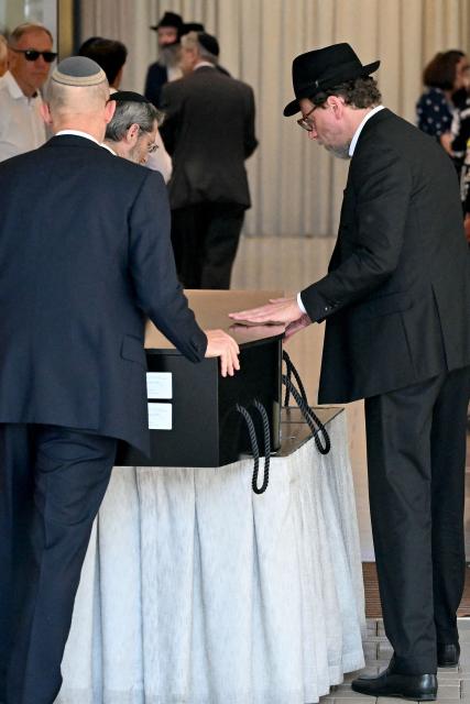 The coffin of Yaakov Levitan, who was killed in the December 14 Bondi beach shooting attack, arrives at the Macquarie Park Cemetery in Sydney on December 17, 2025. Australia held the first funeral on December 17 for victims of the Bondi Beach mass shooting, as large crowds gathered to grieve a rabbi slain in the attack. Sajid Akram and his son Naveed opened fire on a Jewish festival at the famed surf beach on December 14 evening, killing 15 people and wounding dozens more. (Photo by Saeed KHAN / AFP)