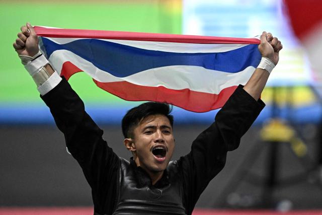 Thailand’s Peerapon Mitasarn celebrates after winning against Malaysia’s Muhammad Izzul Irfan Marzuki in the men’s individual Pencat Silat final during the 33rd Southeast Asian Games (SEA Games) at IMPACT Arena in Nonthaburi on December 17, 2025. (Photo by Lillian SUWANRUMPHA / AFP)