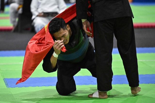 Vietnam’s Tan Sang Nguyen reacts after winning against Thailand’s Suthat Bunchit in the men’s individual Pencat Silat final during the 33rd Southeast Asian Games (SEA Games) at IMPACT Arena in Nonthaburi on December 17, 2025. (Photo by Lillian SUWANRUMPHA / AFP)