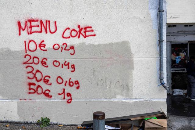 (FILES) This photograph shows graffitis indicating drug prices on the walls of The Bel Horizon tower, located in the 3rd arrondissement of Marseille, on December 3, 2025. Authorities are struggling to find solutions to curb the influx of youths recruited via social media into drug trafficking organizations - and often coerced into staying in service of the gang - a form of "modern day slavery". (Photo by Miguel MEDINA / AFP)