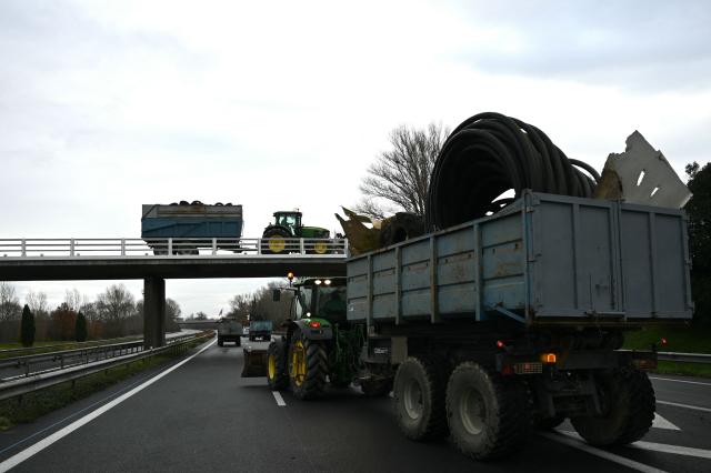 Farmers from the Young Farmers (JA - Jeunes Agriculteurs) union drive tractors and agricultural vehicles to Carcassone on the A61 motorway, in Castelnaudary, southwestern France, on December 17, 2025, as part of a nationwide action by farmers to protest against the government's mandatory culling protocol for cattle herds affected by lumpy skin disease (dermatose nodulaire contagieuse). The viral disease first detected in France in June 2025 that has led to the slaughter of over 3,000 cattle across more than 110 outbreaks nationwide. (Photo by Matthieu RONDEL / AFP)